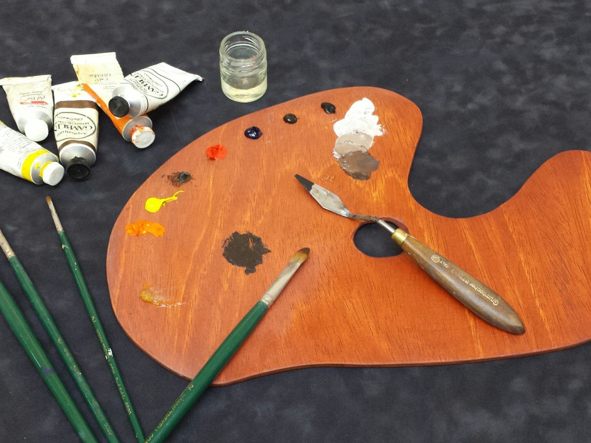 Wooden palette with oil paints, brushes and palette knife