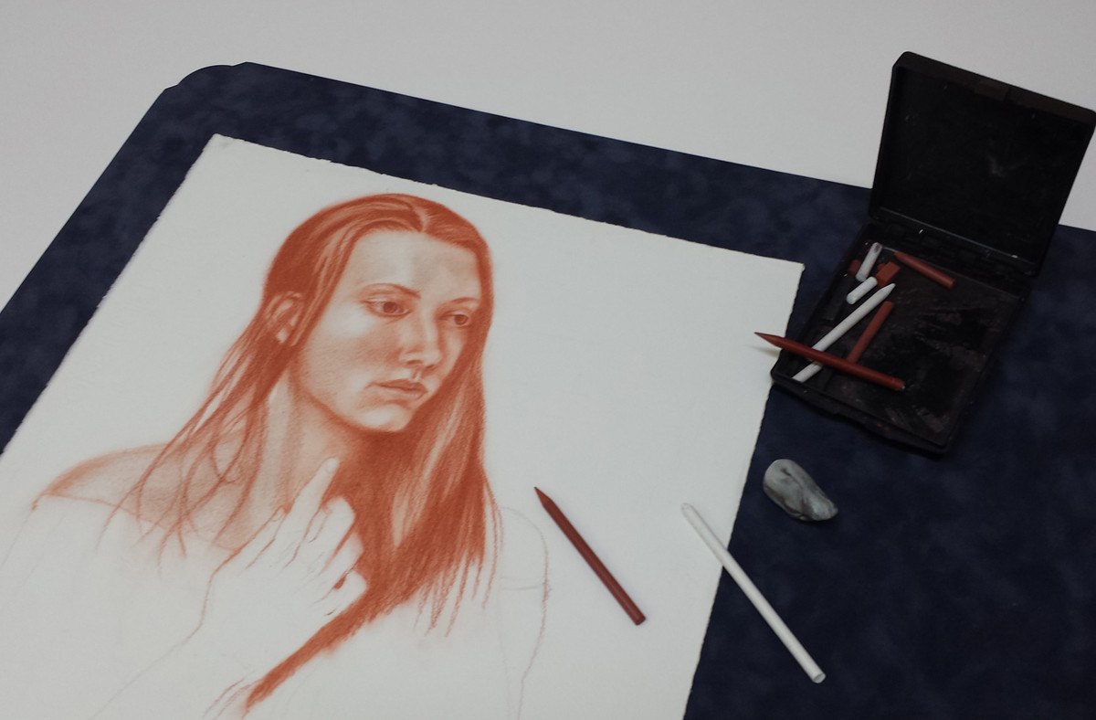 A sanguine chalk drawing of a woman in progress